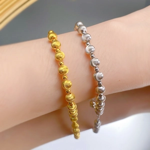 Macro detail of brushed metal beads in gold and silver finish on elegant bracelets