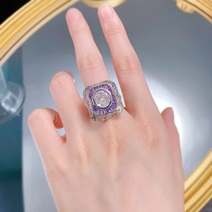Macro detail of S925 silver ring featuring white oval gemstone and purple side stones