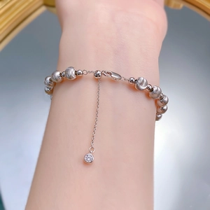 Macro detail of S925 sterling silver beaded bracelet with brushed texture and lobster clasp