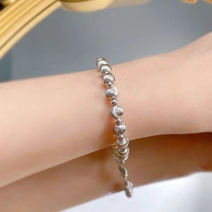 Macro shot of silver beaded bracelet with brushed texture on female wrist