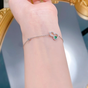 Detail of S925 silver hulu bracelet with green gemstone and pavé diamonds on woman wrist