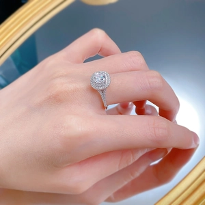 Luxurious cushion-cut silver ring with double halo and pavé band worn on a finger