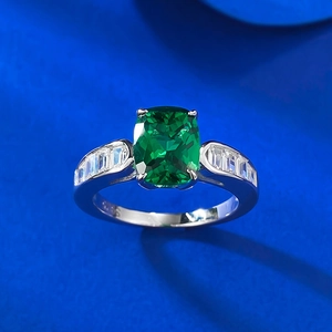 S925 sterling silver ring with cushion cut green gemstone and side stones on blue velvet