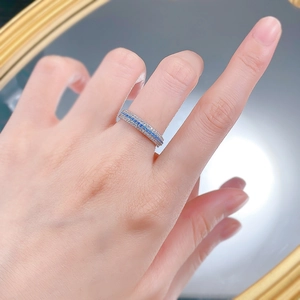 Close-up of S925 silver ring with rows of vibrant blue and white stones on a finger