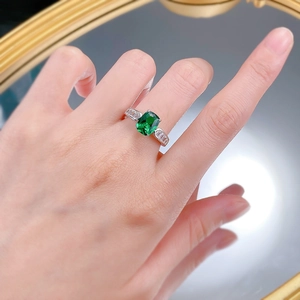 Close-up of S925 silver ring with emerald-cut green gemstone and side diamonds