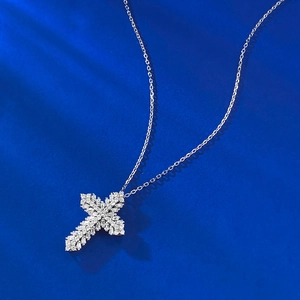 Detailed view of S925 silver cross pendant with sparkling zircons on blue background