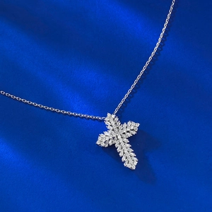 Elegant S925 silver cross pendant necklace with sparkling cubic zirconia on blue surface