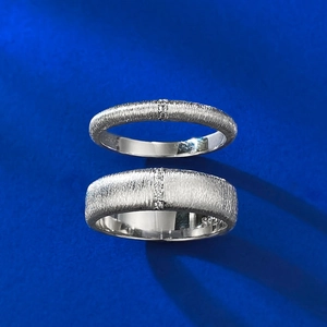 Detailed view of brushed S925 sterling silver rings with micro-set diamonds on blue