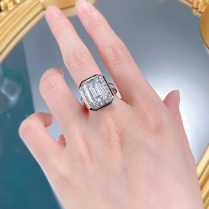 Macro detail of emerald cut solitaire ring with halo setting on reflective mirror