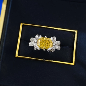 Vue macro de bague avec pierre jaune 7x9mm et nœuds en diamants dans son écrin bleu