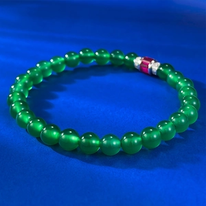 Macro shot of S925 silver beaded bracelet with translucent green jadeite and red agate
