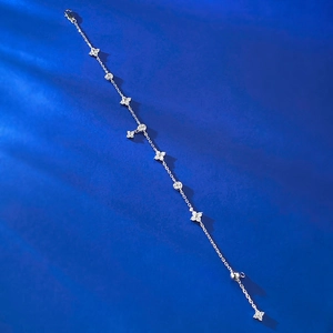 Détail d'un bracelet en argent avec des pendentifs trèfle et des zircons scintillants