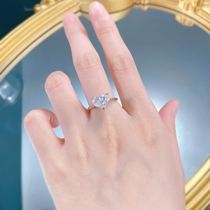 Gros plan d'une bague solitaire en forme de cœur portée à la main avec miroir élégant
