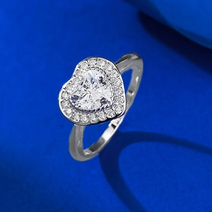 Gros plan d'une bague en diamant en forme de cœur avec serti pavé sur fond bleu