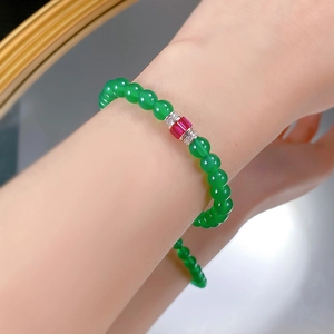 Close-up of green chalcedony beaded bracelet with red gemstone center and silver accents