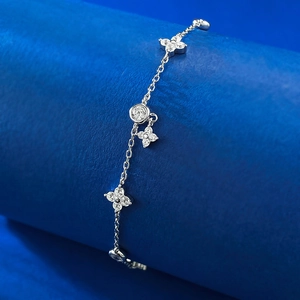 Vue détaillée du bracelet à pampilles en argent S925 avec breloques fleurs sur support bleu