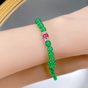 Detail of S925 silver bracelet with green agate beads and a faceted red gemstone