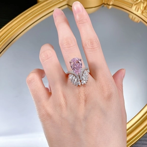 Macro shot of S925 silver ring featuring a large pink pear-cut gem and marquise stones