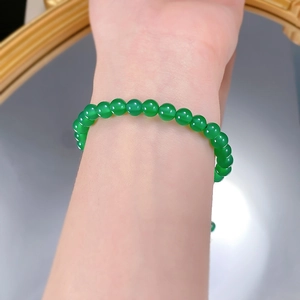 Close-up of a green jade chalcedony bead bracelet with translucent oily luster on wrist