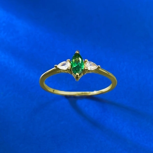 Detailed macro view of marquise-cut emerald stone on gold-plated S925 silver ring