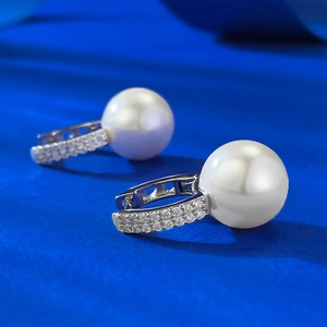 Macro shot of 11mm white pearl earrings with micro-pave crystals on silver U-shaped clasp