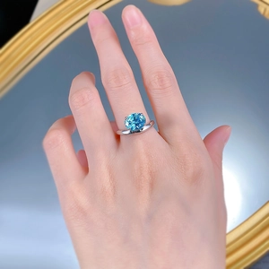 Macro detail of a 925 silver ring featuring an oval blue carbon diamond in a four-claw setting