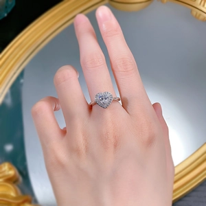 Détail d'une bague en argent S925 avec halo en forme de cœur portée au doigt