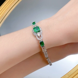 Art Deco silver bracelet with emerald cut green gemstones and diamonds on wrist