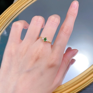 Marquise green emerald S925 sterling silver ring worn on hand with golden mirror background