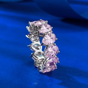 Macro view of teardrop pink stones set in a silver eternity band with claw setting