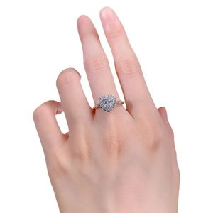 Bague cœur en argent S925 avec diamant blanc portée sur la main, fond blanc épuré