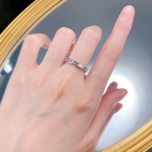 Détail macro de la bague coeur avec zircons violets et texture en métal brossé