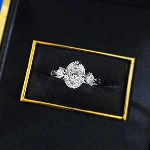 Three-stone S925 silver ring featuring a large oval cut diamond on a black velvet box