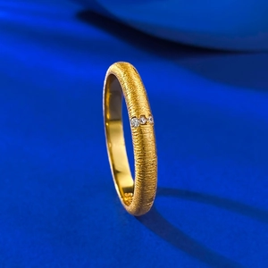 Macro shot of S925 silver gold-plated ring with brushed texture and three inset stones