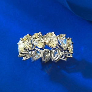 Macro detail of luxury pear-cut yellow diamond halo ring in sparkling silver setting