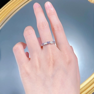 Détail des pierres violettes et blanches en forme de cœur sur bague argentée