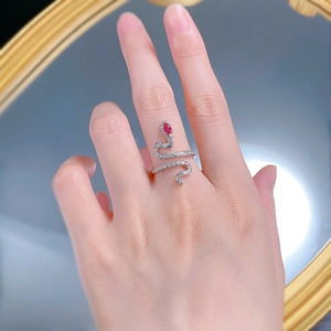 Macro shot of silver snake ring with pavé zircons and a red teardrop stone on finger