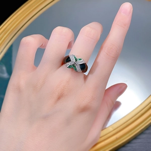 Detailed view of S925 silver ring featuring crisscross design with green and black enamel