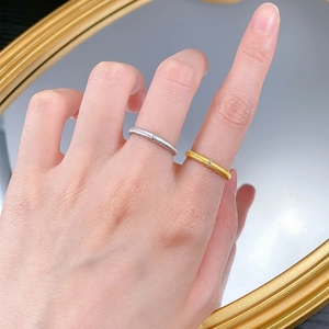 Close-up of minimalist brushed silver and gold rings with a tiny sparkling stone inlay