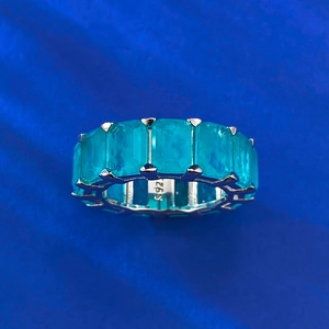 Gros plan d'une bague en argent 925 avec des pierres de paraiba de taille émeraude
