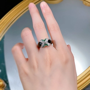 Detail of S925 silver ring featuring emerald gemstone and black enamel on a hand