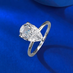 Elegant S925 sterling silver ring with a large pear cut white gemstone on blue silk