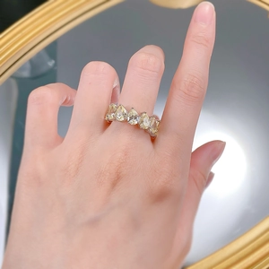 Detail of five pear-cut yellow gemstones set in a gold luxury multi-stone band on hand