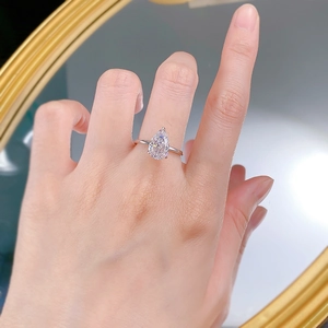 Macro shot of S925 silver pear cut white zircon ring worn on finger with mirror background