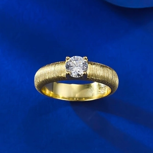 Macro detail of S925 gold plated ring showing brushed texture and four-prong diamond setting