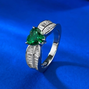 Gros plan d'une bague en argent 925 avec émeraude en cœur et diamants fuselés