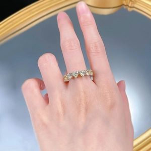 Dettaglio di un anello in argento con una fila di diamanti gialli a forma di cuore