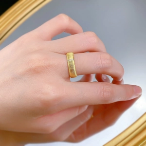 Macro detail of gold brushed ring featuring vertical texture and small zircon inlay