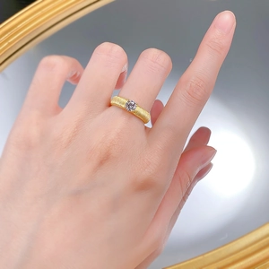 Macro view of gold-plated S925 silver ring featuring ribbon brushed texture and a single diamond