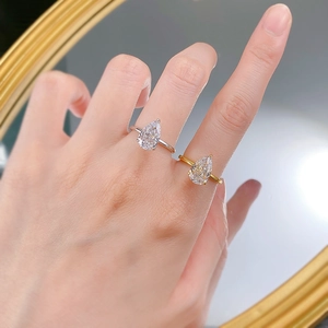 Gros plan de bagues poire avec taille fleur de glace en finitions argent et or sur miroir